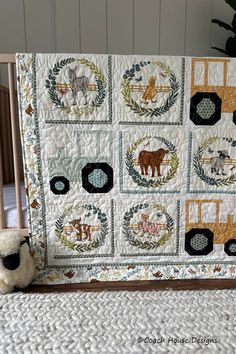 a teddy bear sitting in front of a quilted baby's nursery crib