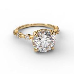 a yellow gold engagement ring with an oval cut diamond in the center and side stones