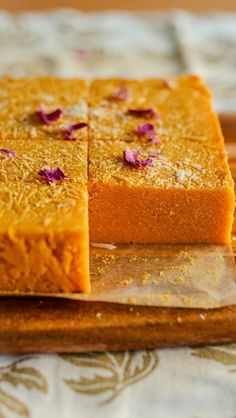 three pieces of cake sitting on top of a cutting board