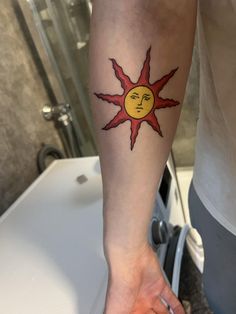 a person with a sun tattoo on their arm