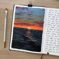 an open notebook with a sunset on the water