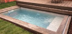 a small pool in the middle of a decked area with steps leading up to it