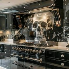 a kitchen with black cabinets and skulls painted on the backsplash, along with stainless steel appliances