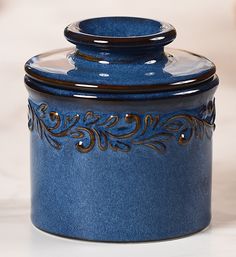 a blue canister sitting on top of a white counter next to a black lid