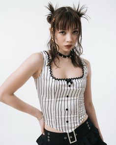 a woman with her hands on her hips wearing a black and white striped crop top