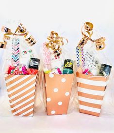 three orange and white polka dot bags filled with candies, lollipops and candy