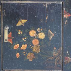 a painting with flowers and butterflies painted on it's side, next to a light switch