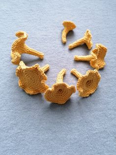 several crocheted objects arranged in the shape of a circle on a blue surface