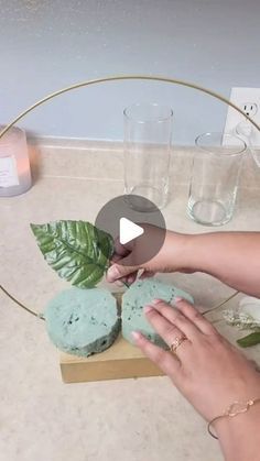 a woman is decorating some cupcakes with green frosting on a table