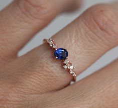 Blue sapphire and diamond cluster ring made in 14k, 18k gold or platinum, depicted in rose gold. September birthstone ring, engagement ring or simply a gift for her. ★Details Main stone: ceylon blue sapphire Weight: approx. 0.8 ct, 5 x 3.50 mm Diamonds: approx. 1.25 mm, (2) 1.50 mm, (4) 1.75 mm (2) Side stones: white diamonds Quality: color grade G, VS clarity grade, conflict-free Band measurements: approx. 1.5mm wide Material: 14k solid yellow gold, white gold, rose gold or 18k solid yellow gol Sapphire Cluster Ring, Diamond Ring Unique, Ring Blue Sapphire, Blue Sapphire Diamond Ring, Blue Sapphire Engagement Ring, September Birthstone Rings, Buying An Engagement Ring, Blue Sapphire Ring, Unique Diamond Rings