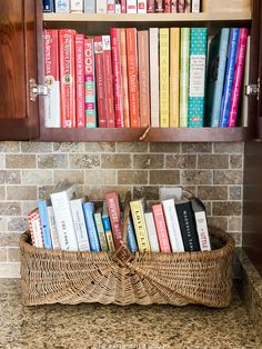 a basket filled with books sitting on top of a counter next to a book shelf