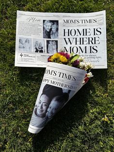 flowers and newspaper lying on the ground in front of a news paper that says, moms times is where moms are