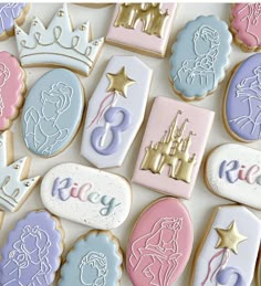 cookies decorated with royal and princess icing are arranged on a white surface, including one cookie