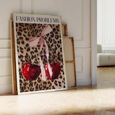 a fashion poster with two heart shaped cherries tied to it's sides in front of a leopard print wall