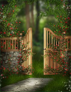 an open wooden gate in the middle of a lush green field with flowers and trees