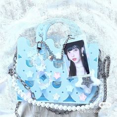 a blue purse with an image of a woman's face hanging from the front