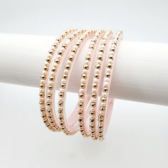 Add a touch of elegance to your wrist with Manisha glass bangles. The light matte pink hue adds a subtle pop of color, while the soft gold accents bring a touch of glamour. Perfect for any occasion, these bangles are both playful and chic. *Sold as a set of six. *To avoid damage, put on each glass bangle one at a time. If your regular bangle size fits tightly, we recommend going up a size. Glass Bangles, Twitter Icon, Matte Pink, Instagram Icons, Bangles Jewelry, Pink Pearl, Gold Design, Gold Accents, The Light