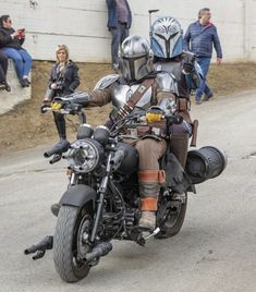 a man riding on the back of a motorcycle down a street