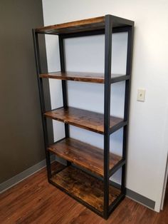 an empty shelf in the corner of a room with wood flooring and white walls