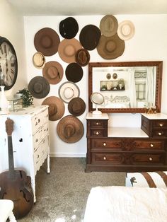 a room with many hats on the wall and a guitar in the foreground,