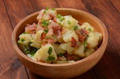 a wooden bowl filled with potatoes and bacon