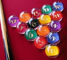 a pool table with many different colored balls and cuesticks next to each other