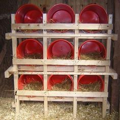 several red plates are stacked on top of each other in a pallet with hay