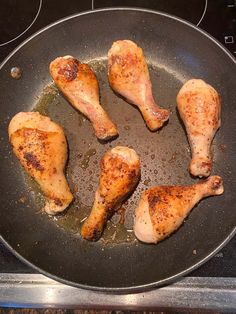 chicken legs are cooking in a pan on the stove