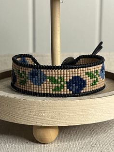 a wooden stand with a beaded bracelet on it