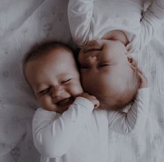 black and white photograph of two babies smiling