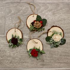 four pieces of wood with flowers and greenery hanging from the sides on a wooden floor