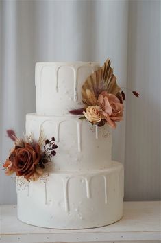 a three tiered white cake with flowers on top