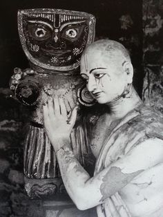 an old black and white photo of a woman holding a vase in front of her face