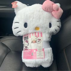 a hello kitty stuffed animal sitting on top of a car seat