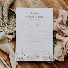 a baby dedication card sitting on top of a wooden table next to some cloths