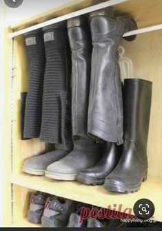 several pairs of boots are lined up on the shelf in front of eachother