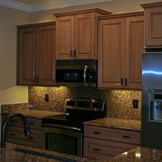 a kitchen with granite counter tops and wooden cabinets