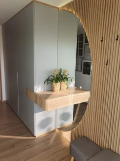 a room with a mirror and some plants on the table in it's corner