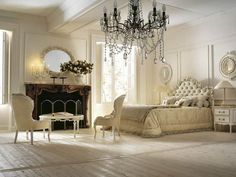 an elegant bedroom with chandelier, mirror and bed in white color palettes