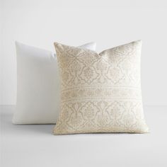 two white pillows sitting next to each other