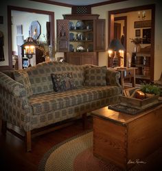 a living room filled with furniture next to a wooden table and two lamps on either side of the couch