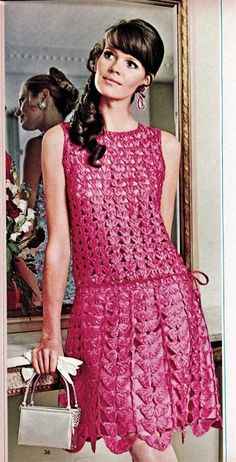 an old fashion photo of a woman in a pink lace dress and matching heels, standing next to a mirror