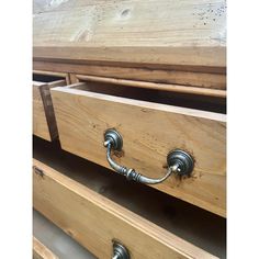 two drawers with metal handles are shown in this close up photo, and the bottom drawer is made out of wood