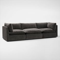 a large gray couch sitting on top of a white floor