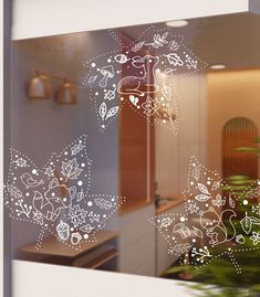 the window is decorated with white flowers and leaves in front of a kitchen countertop