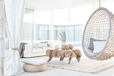 a living room filled with furniture and a hanging chair