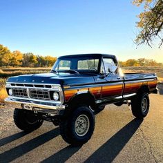 an old pickup truck is parked on the side of the road