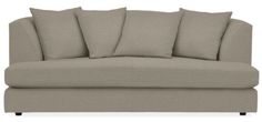 a gray couch with four pillows on it's back and one arm facing the camera