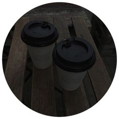 two coffee cups sitting on top of a wooden table