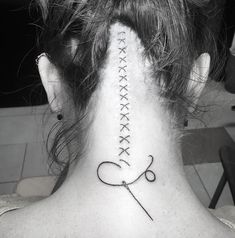 a woman's back neck with a tattoo on it that says love and scissors